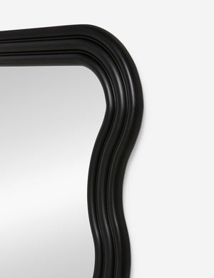 Close-up of the right corner of the Wendolyn wavy thick-framed black wall mirror.