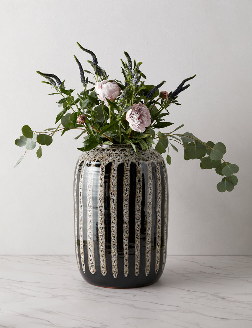 | Wheaton full-bodied black and natural striped vase with flowers inside