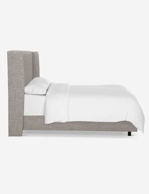 Side view of Adara light gray linen upholstered bed.