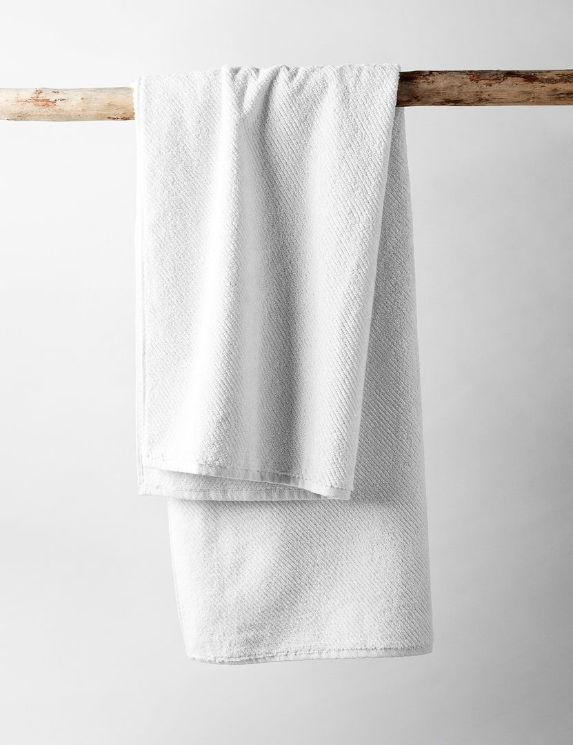 #color::white | The white turkish cotton Air Weight Towel Set by Coyuchi hangs over a wooden branch