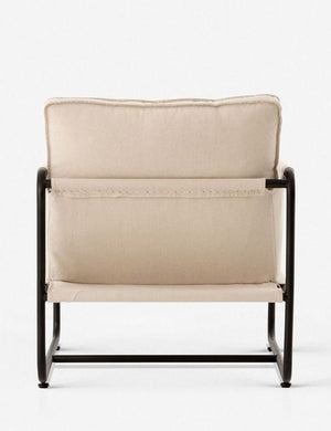 Rear view of the Alena accent chair with cream linen cushions and black metal frame