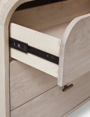 Close-up on the drawer glides on the Brooke whitewashed oak 6-drawer rounded dresser with iron drawer pulls