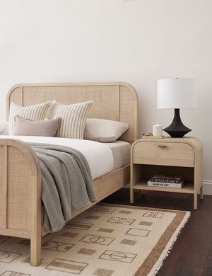 The Brooke one drawer whitewashed nightstand sits next to the Brooke platform bed next to a patterned rug