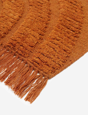 The fringed corner of the Arches rust orange Rug