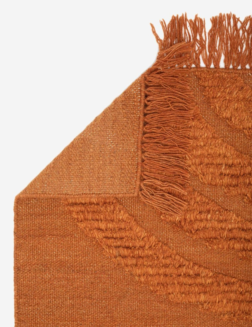 #size::2--x-3- #size::3--x-5- #size::5--x-8- #size::8--x-10- #size::9--x-12- #color::rust #size::10--x-14- | The corner of the Arches rust orange Rug folded over itself