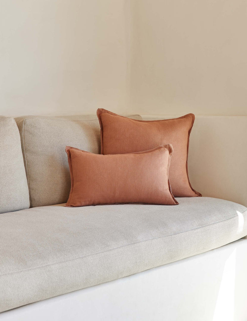 #color::rust #style::lumbar | The arlo rust orange flax linen pillow in its lumber and square sizes sit together on a natural linen sofa