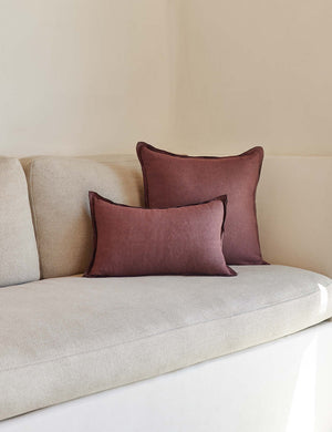 The arlo Aubergine burgundy flax linen pillow in its lumber and square sizes sit together on a natural linen sofa