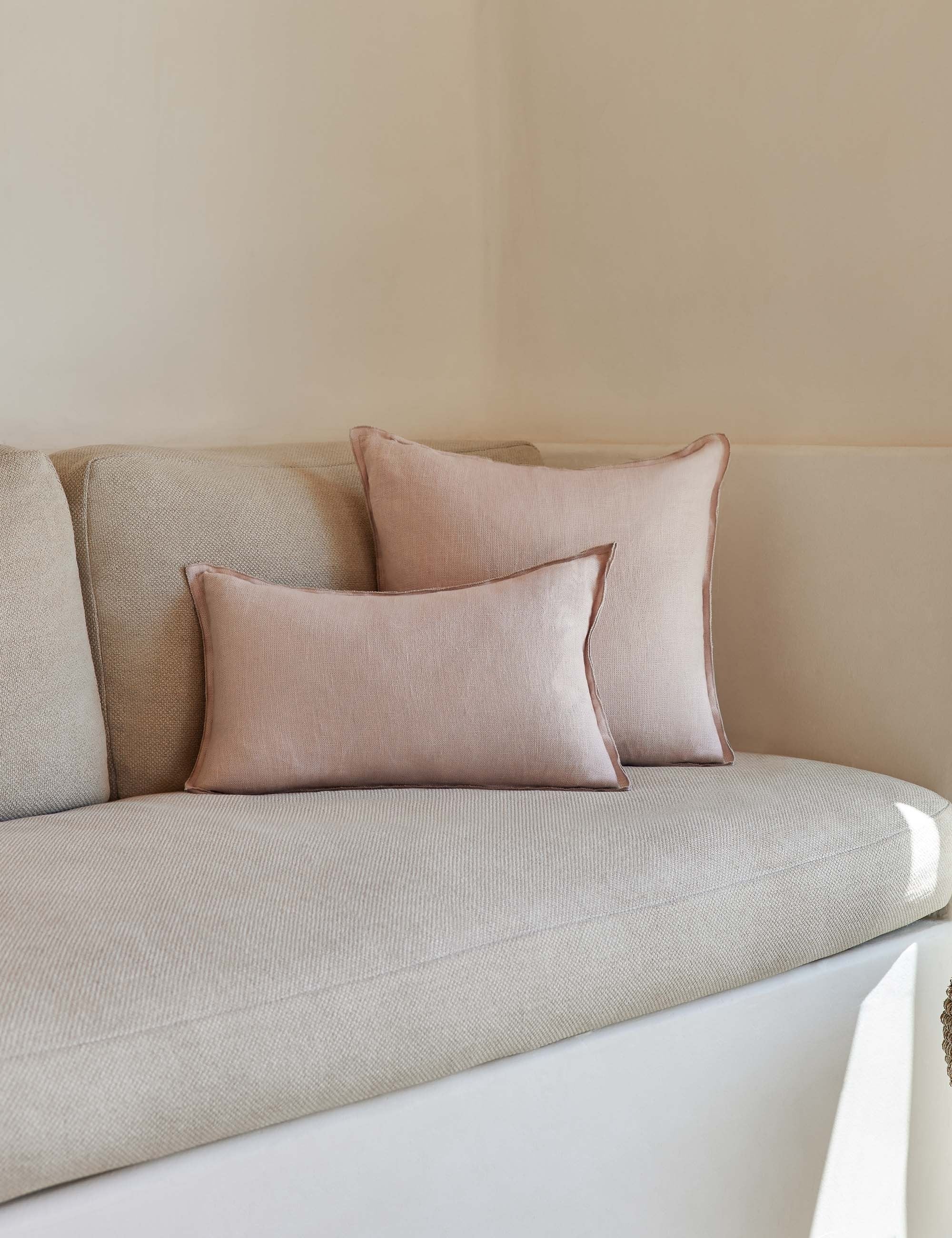 #color::greige #style::square #fill type::with-feather-down-insert #fill type::pillow-cover-only | The arlo Greige flax linen pillow in its lumber and square sizes sit together on a natural linen sofa