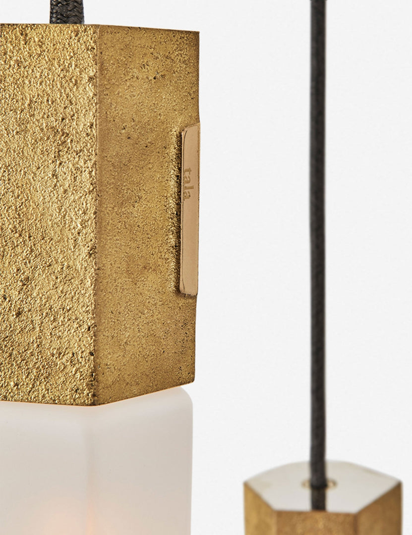 #color::brass | Close-up of the sand casted brass hardware on the Basalt slender hexagonal 9-light pendant light by tala