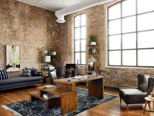 The Camden Leather Office Chair sits in a rustic office space with exposed brick walls and high ceilings