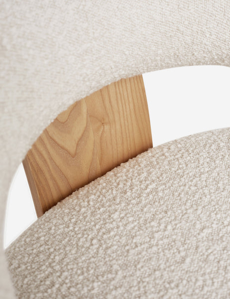 #color::cream | Close-up of the wood-panel back support and white boucle fabric on the wishbone frame of the Celeste honey wood accent chair 