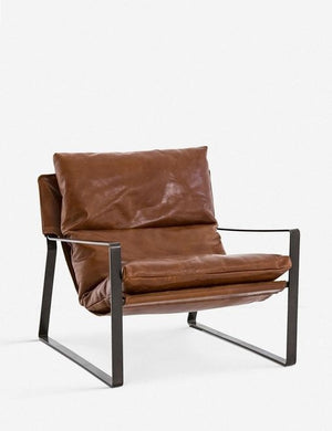 Angled left side view of brown leather Marlyne sling-back accent chair with black metal frame