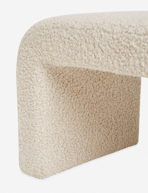 Close-up of the boucle texture on the inner leg and side of the Tate cream upholstered bench.