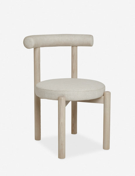 | Angled left view of the Dame minimalist rounded open-back dining chair with ivory upholstered seat and ash wood frame