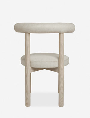 Rear view of the Dame minimalist rounded open-back dining chair with ivory upholstered seat and ash wood frame