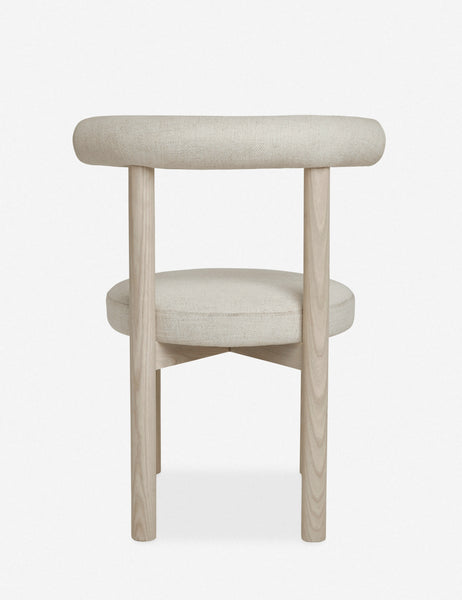 | Rear view of the Dame minimalist rounded open-back dining chair with ivory upholstered seat and ash wood frame