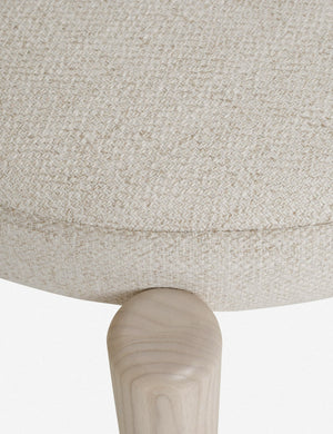 Close-up of the seat fabric of the Dame minimalist rounded open-back dining chair with ivory upholstered seat and ash wood frame