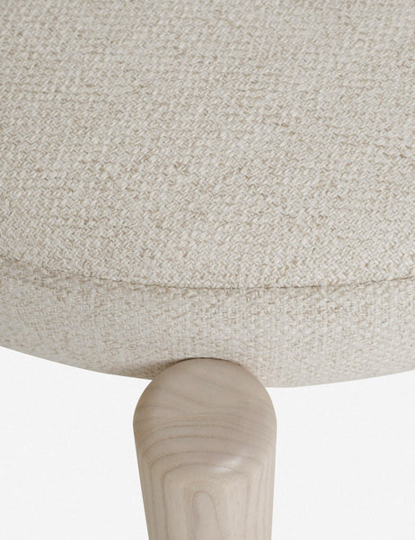 #color::whitewash | Close-up of the seat fabric of the Dame minimalist rounded open-back dining chair with ivory upholstered seat and ash wood frame