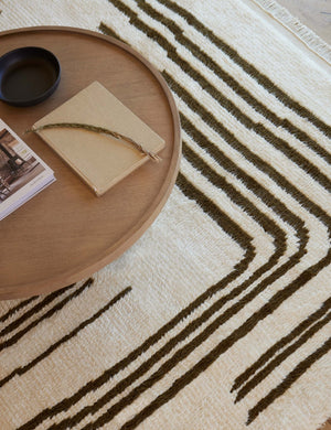 Close up of the Earth Maze Moroccan Shag Rug laying under a round wooden coffee table