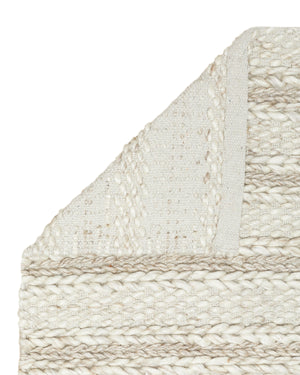 Close-up of the corner of the Estie white rug with thick braids slightly folded over, exposing the underside of the rug