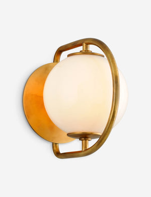 Angled view of the Evangeline diffused white glass orb sconce with brass frame