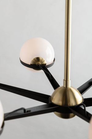 Close-up of the spherical lighting fixtures and the brass center of the Adeline black and brass retro chandelier