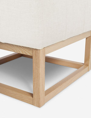 Close up of the airy wooden frame on the bottom of the Grasmere Oyster White Linen Ottoman