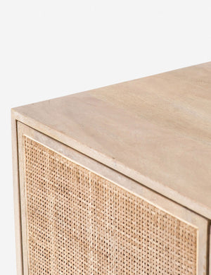 Detailed view of the upper corner of the Hannah natural mango wood sideboard with cane doors and an iron base.