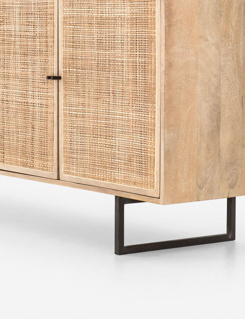 #color::natural | Close-up of the metal cylindrical handles, iron base, natural wood, and cane detailing of the Hannah black mango wood sideboard.