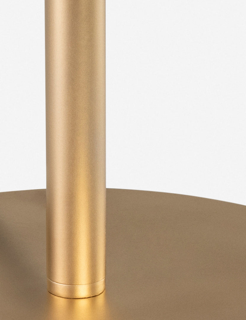 #color::gold | Close-up of the slim round base on the Luz gold table lamp
