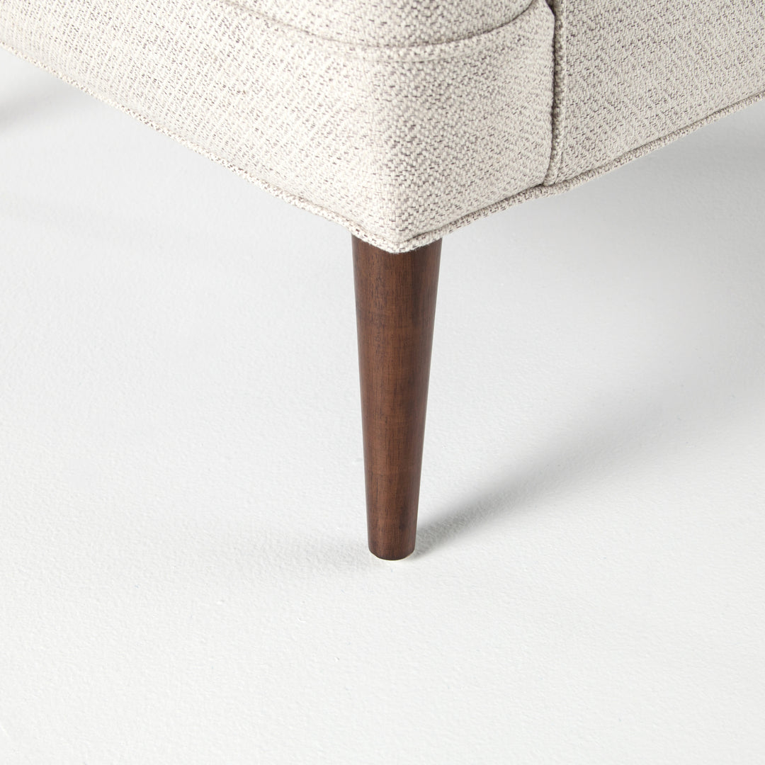 | The tapered dark wooden legs on the Ilona accent chair