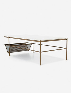 Angled view of the Thina rectangular marble coffee table with gold hardware and magazine shelf