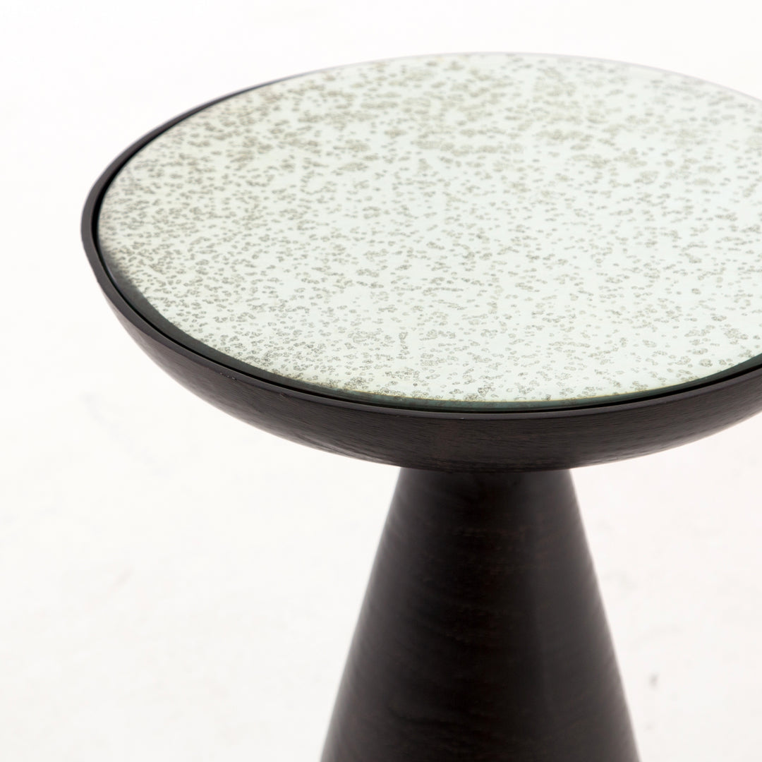 | Close-up of the upper-half of the Bridget bronze pedestal side table with mirror ash glass top