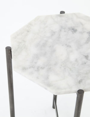 Angled-upper view of the top of the Gianea side table with geometric white marble top and black metal frame