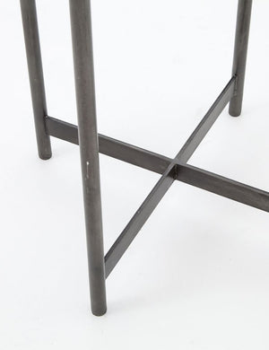 Close-up of the base of the Gianea side table with geometric white marble top and black metal frame
