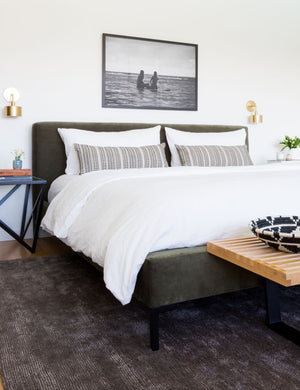 The Deva Deva Moss platform bed lays in a bedroom under a wall art atop a gray plush rug