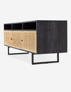 Angled view of the Hannah black mango wood media console with cane doors.