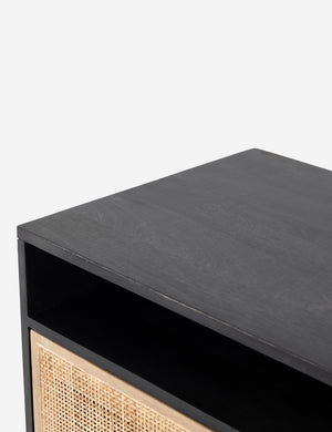 Close-up of the top of the Hannah black mango wood media console with cane doors.