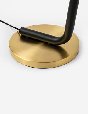 Close-up of the brass circular base on the Jeffery sleek black pipe floor lamp with brass hardware