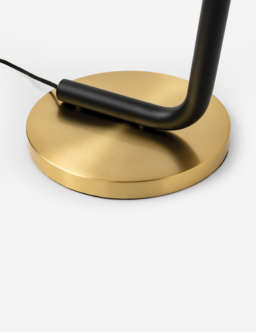 | Close-up of the brass circular base on the Jeffery sleek black pipe floor lamp with brass hardware