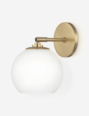 Angled view of the Kai bistro-style sconce with brass hardware