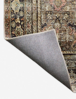 Close-up of the corner of the Dacion distressed dark-toned persian rug folded over