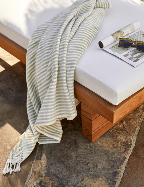 #color::sage-stripe #style::sage-stripe | Sage green and white striped Beach Towel by Business & Pleasure Co hangs off a white cushioned outdoor lounge chair