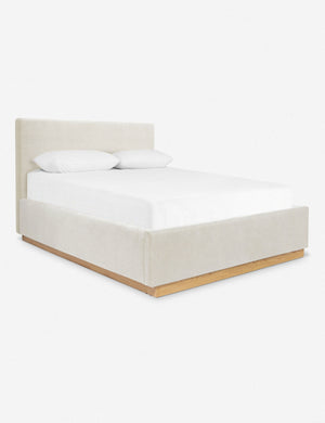 An angled side view of the Lockwood natural velvet-upholstered bed with a white oak base.