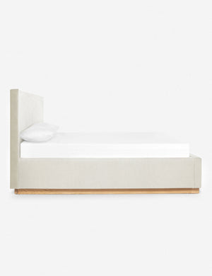 A side view of the Lockwood natural velvet-upholstered bed with a white oak base.