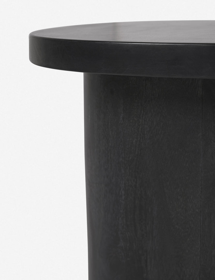 #color::black | Close-up of the rim of the top of the Luna black wood round side table and the leg