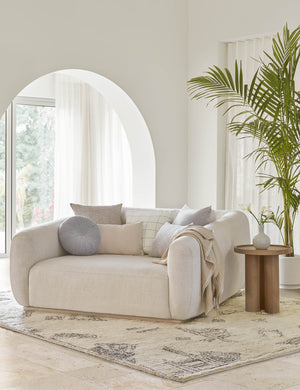 The Giles Moroccan Shag Rug lays in a white-toned room under an ivory linen media lounger with blue and pink throw pillows