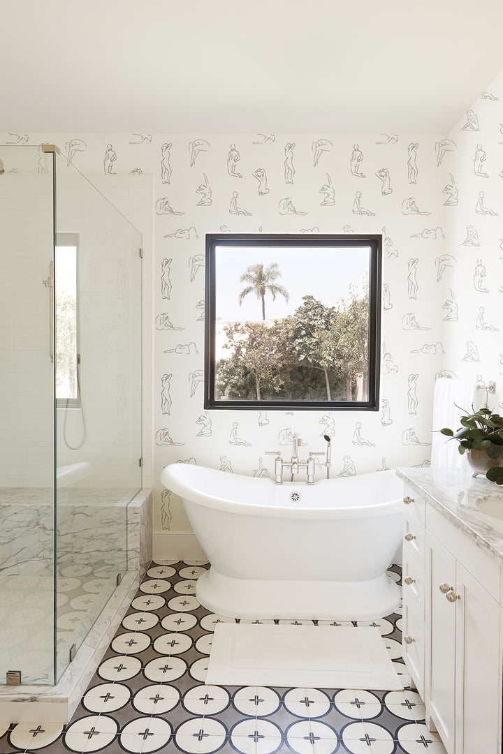 | The Minimalist white and black nude wallpaper is in a bathroom with patterned floors, a white bath tub, and a sink with marble counter tops