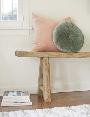 Charlotte rosewater pink square velvet pillow sits on a wooden bench with a light green velvet disc pillow