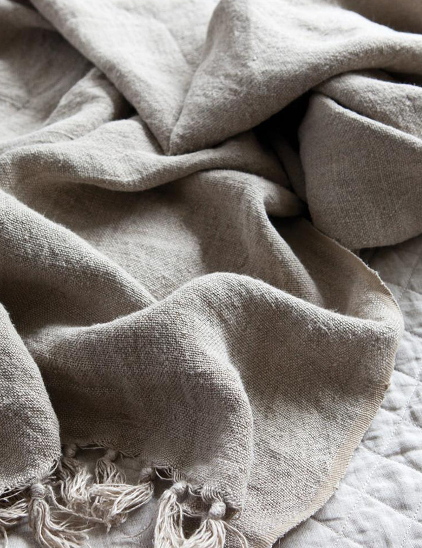 #color::natural #size::110--x-90- #size::90--x-90- | Close up of the Montauk natural linen blanket with tasseled ends by pom pom at home